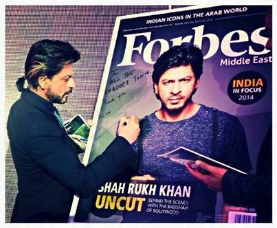 Shahrukh khan giving autograph in forbes magazine.